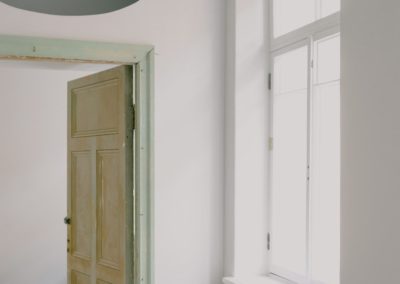 Contemporary apartment interior with shiny window and door near construction materials on floor in daytime